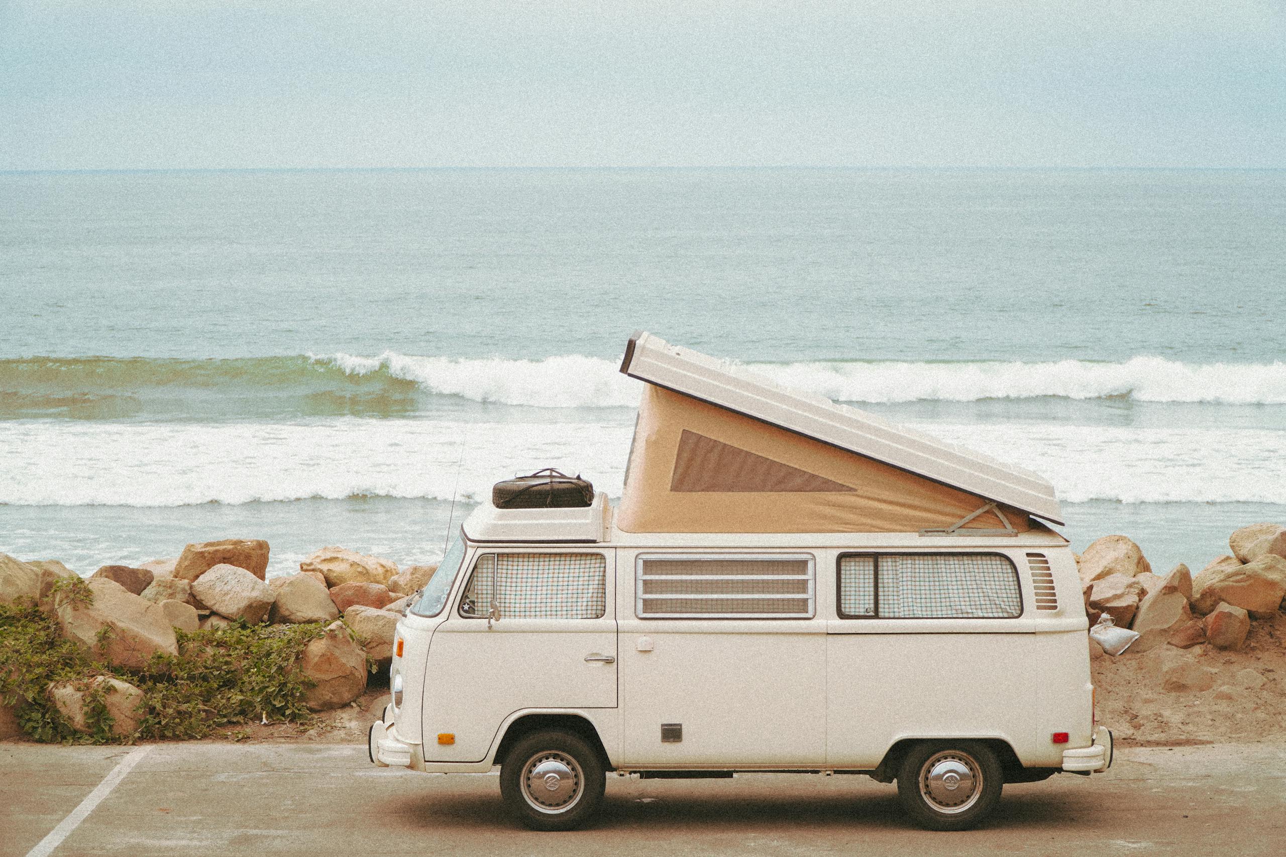 White Van Near the Rocky Shore Seashore